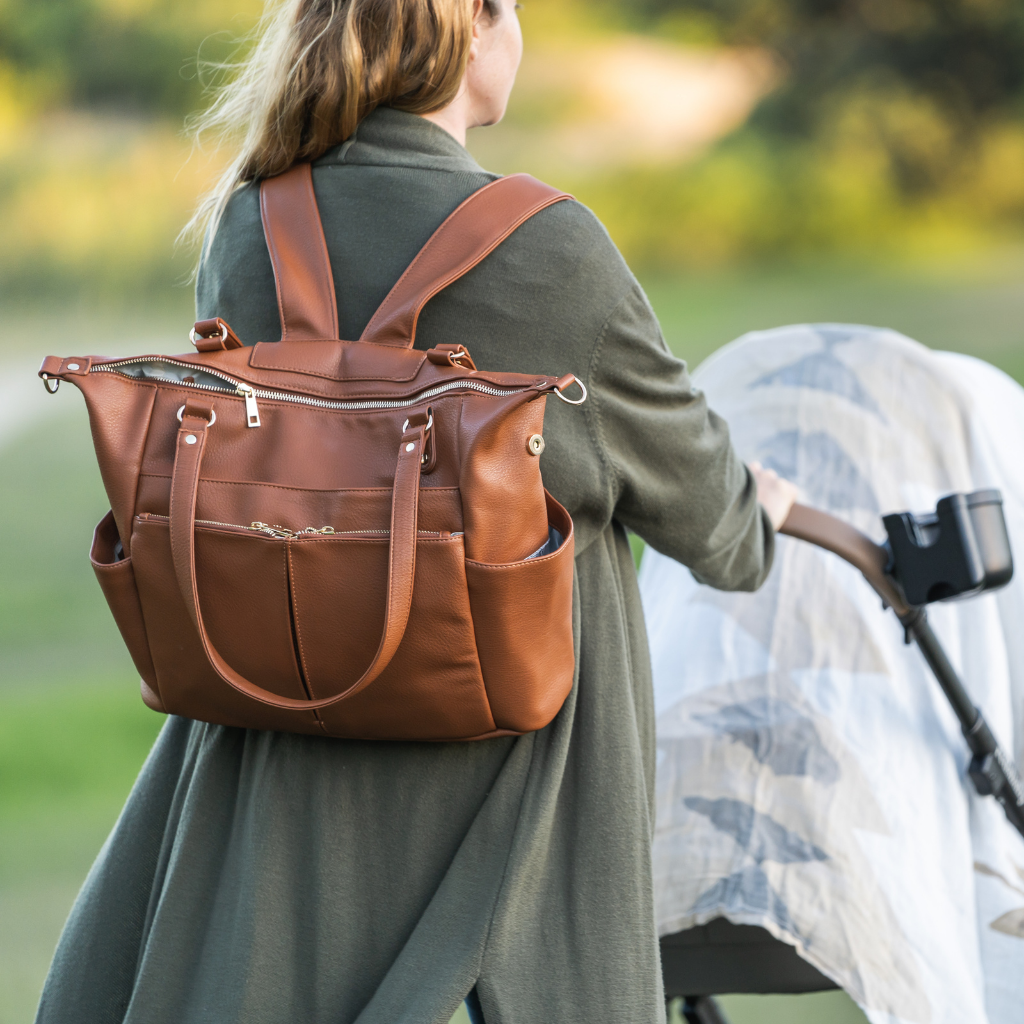 Sofia Vegan Leather Convertible Nappy Backpack - BAmbino Bagz Sofia baby bag is the best convertible nappy bag that goes from tote style nappy bag to backpack nappy bag . Shown in Tan being worn my Mum pushing a pram 