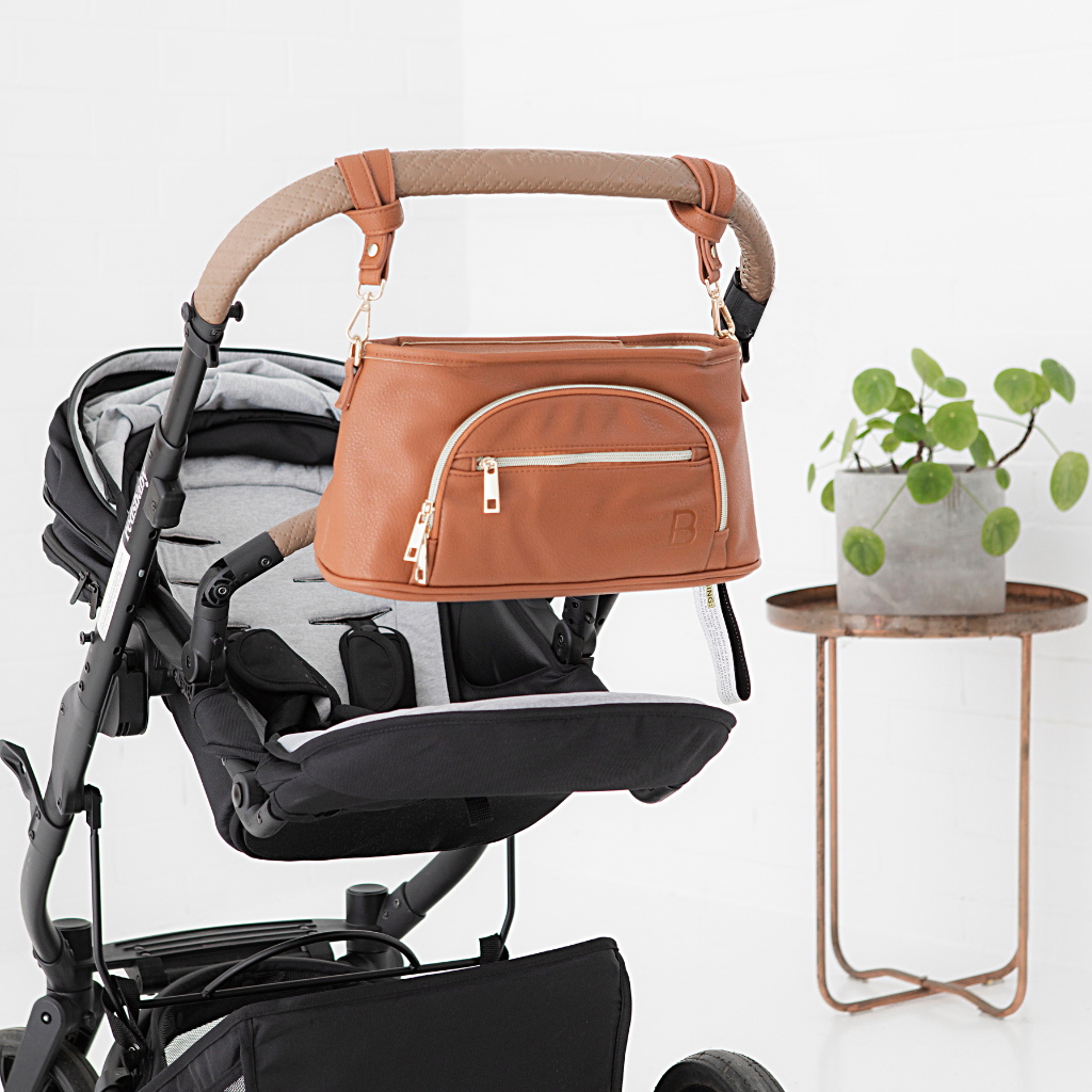 The best pram caddy - Sofia Universal pram caddy in tan clipped onto a pram